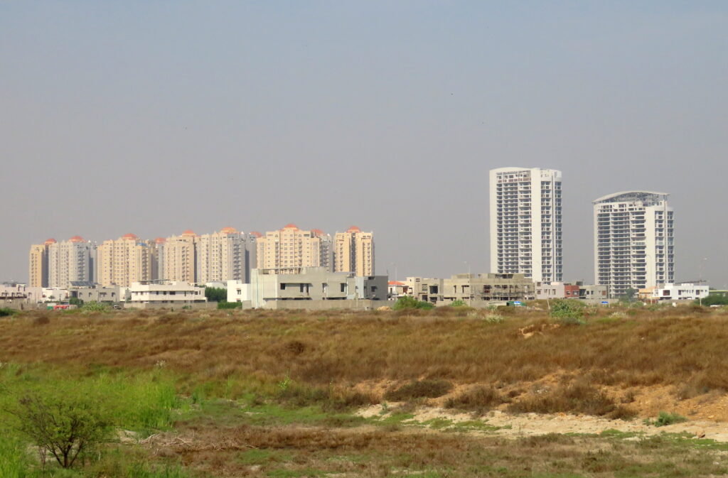 The Creek Vistas towers, left, across open land in DHA Phase 8 in December 2022