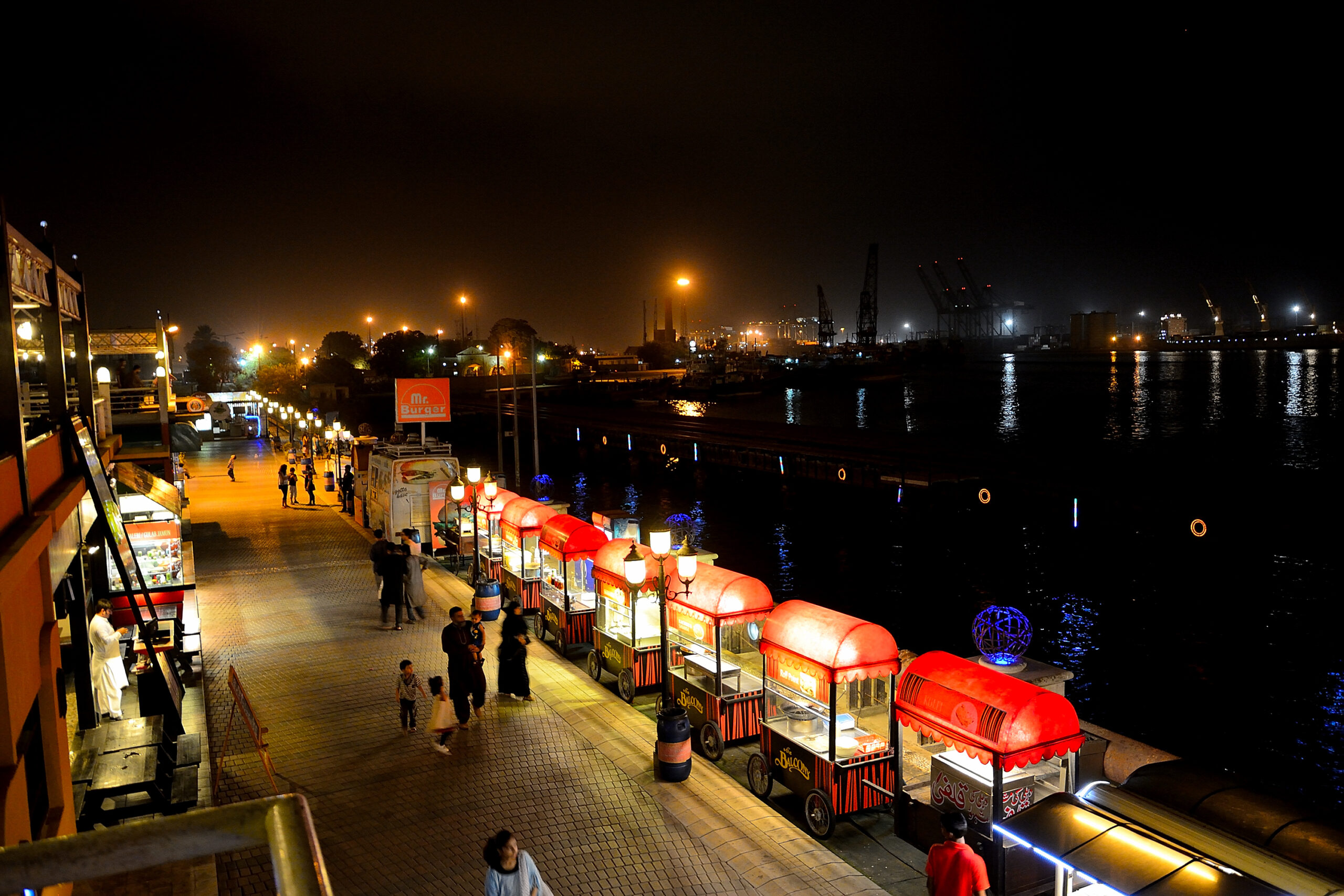 Food stalls line the Port Grand walkway beside China Creek at night