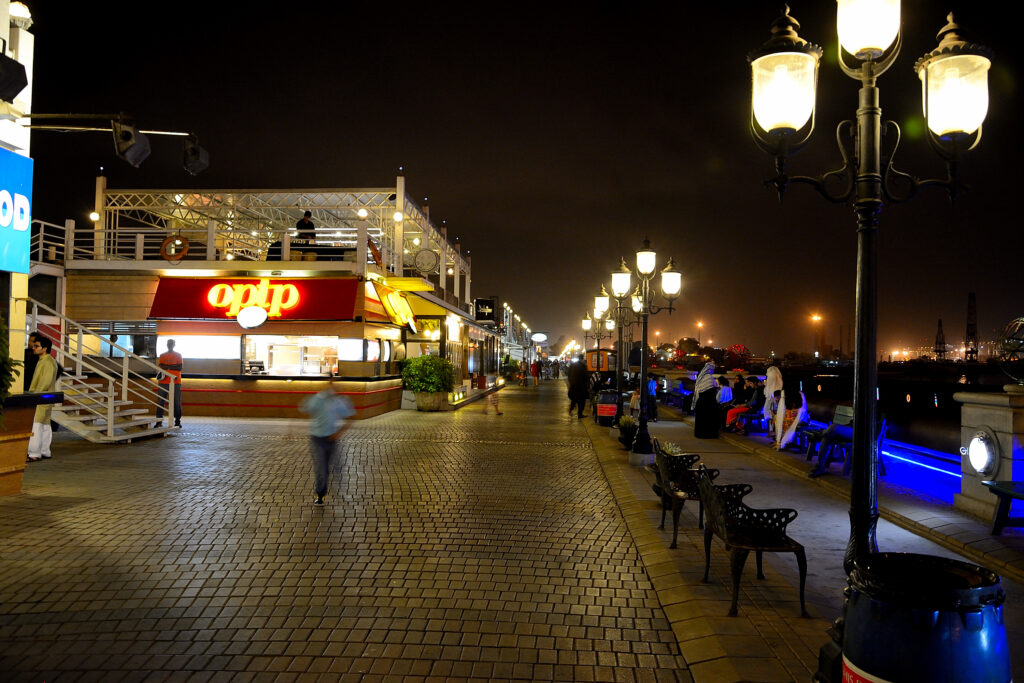 Lamps light the paved promenade and restaurant pavilions at Port Grand