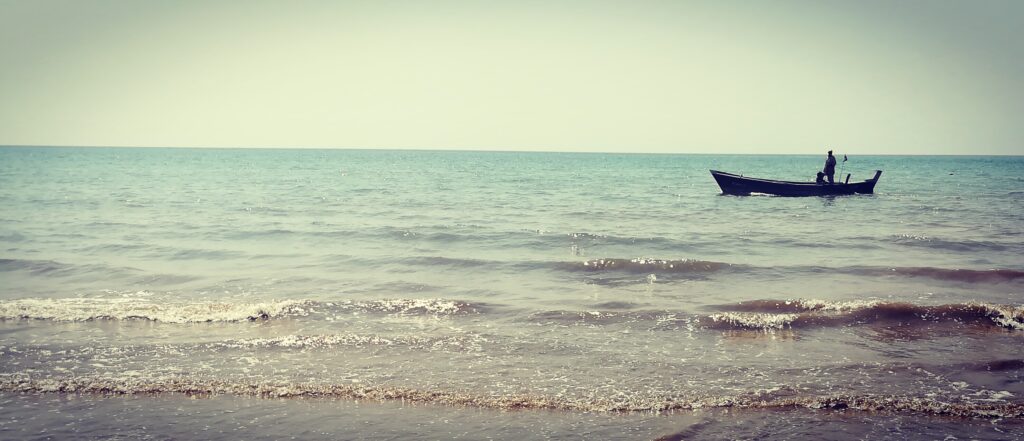 A fishing boat works beyond the surf at Turtle Beach